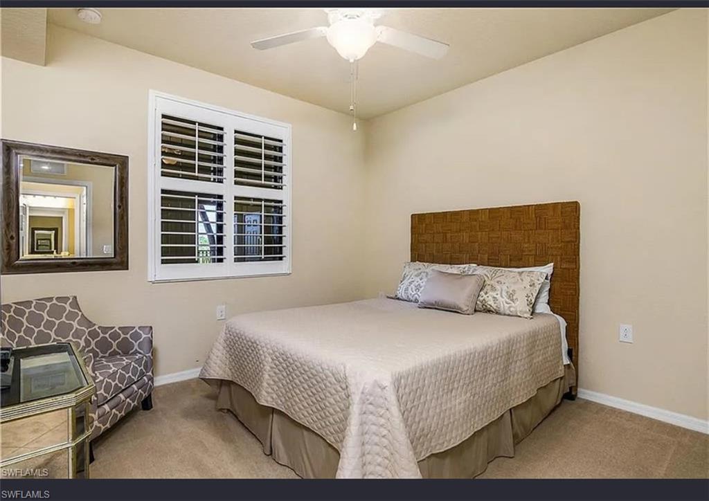 9566 Trevi Court, Unit 4935 Naples, FL 34113 - Photo 8 of 20 a bedroom with a bed wooden floor and window