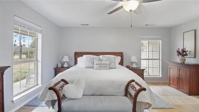 a bedroom with a large bed and windows