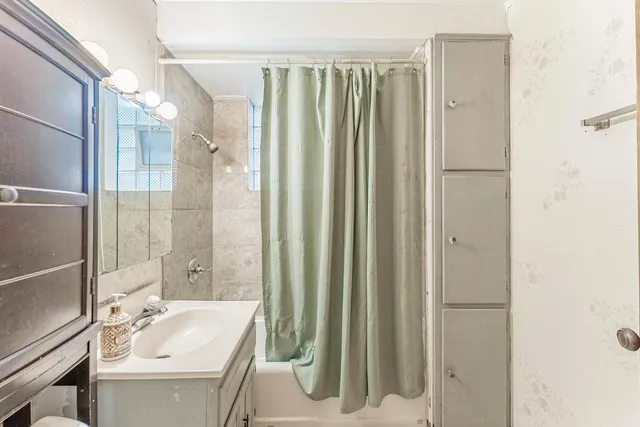 a bathroom with a tub sink and mirror