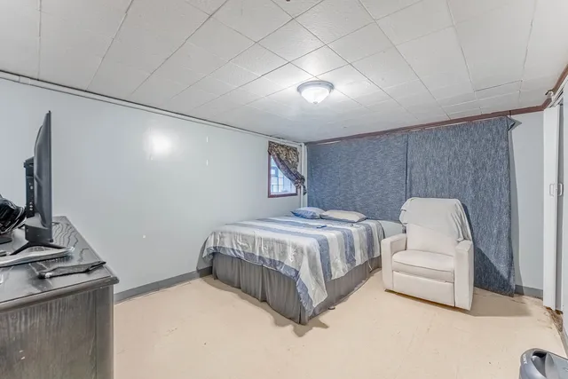 a spacious bedroom with a bed and a flat screen tv