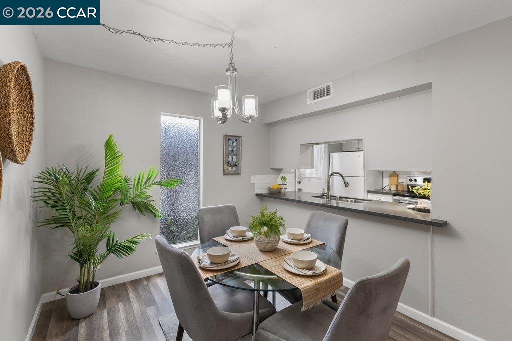 5468 Roundtree Drive, Unit C Concord, CA 94521 - Photo 12 of 27 a view of a dining room with furniture wooden floor and a chandelier