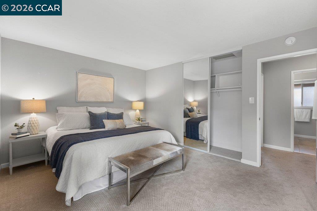 5468 Roundtree Drive, Unit C Concord, CA 94521 - Photo 19 of 27 a bedroom with a bed and a lamp