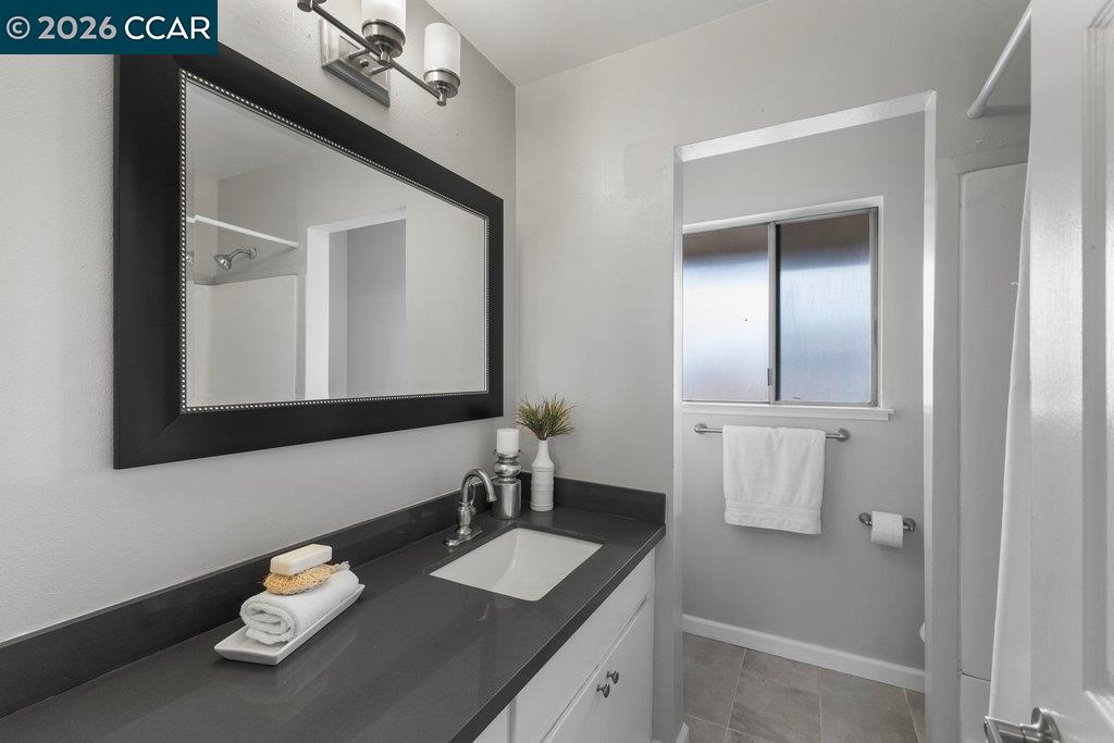5468 Roundtree Drive, Unit C Concord, CA 94521 - Photo 23 of 27 a bathroom with a sink vanity granite and a mirror