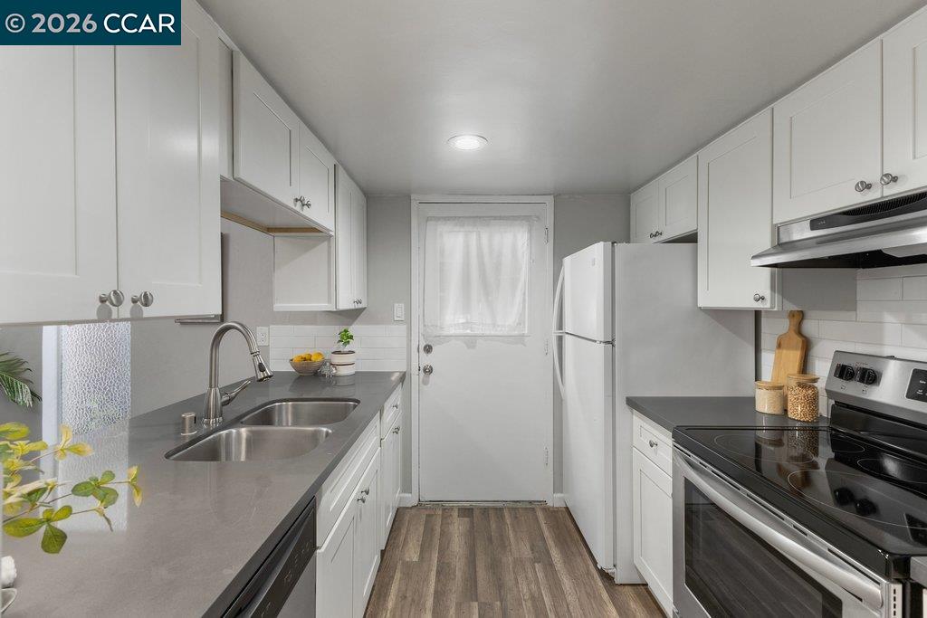 5468 Roundtree Drive, Unit C Concord, CA 94521 - Photo 6 of 27 a kitchen with stainless steel appliances granite countertop a sink stove and refrigerator