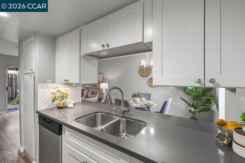 5468 Roundtree Drive, Unit C Concord, CA 94521 - Photo 7 of 27 a kitchen with sink a counter and chairs