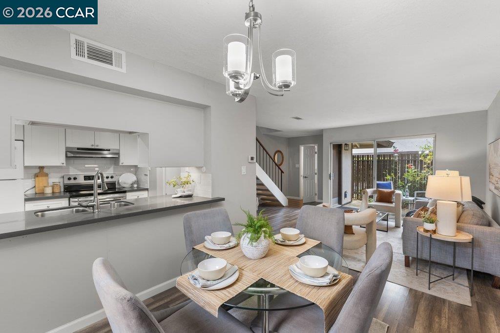 5468 Roundtree Drive, Unit C Concord, CA 94521 - Photo 9 of 27 a view of a dining room with furniture a chandelier and wooden floor