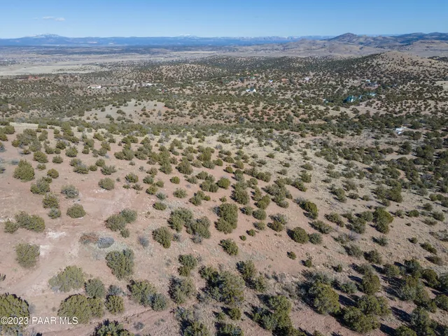 an aerial view of house with yard and mountain view in back