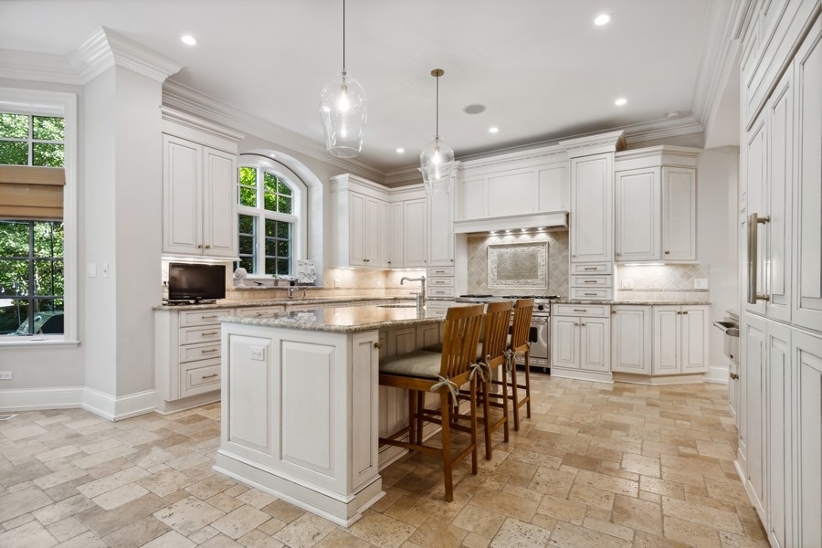 2239 Sheridan Road Highland Park, IL 60035 - Photo 13 of 46 a kitchen with kitchen island granite countertop a table chairs sink and cabinets