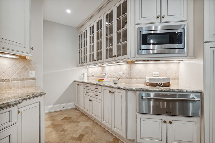 2239 Sheridan Road Highland Park, IL 60035 - Photo 16 of 46 a kitchen with granite countertop white cabinets and stainless steel appliances