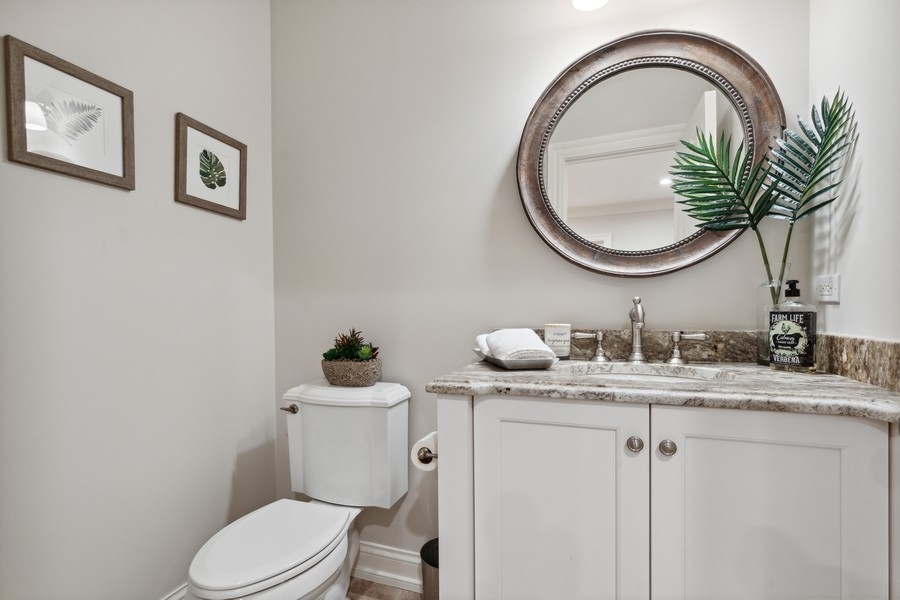 2239 Sheridan Road Highland Park, IL 60035 - Photo 39 of 46 a bathroom with a granite countertop toilet a sink and a mirror