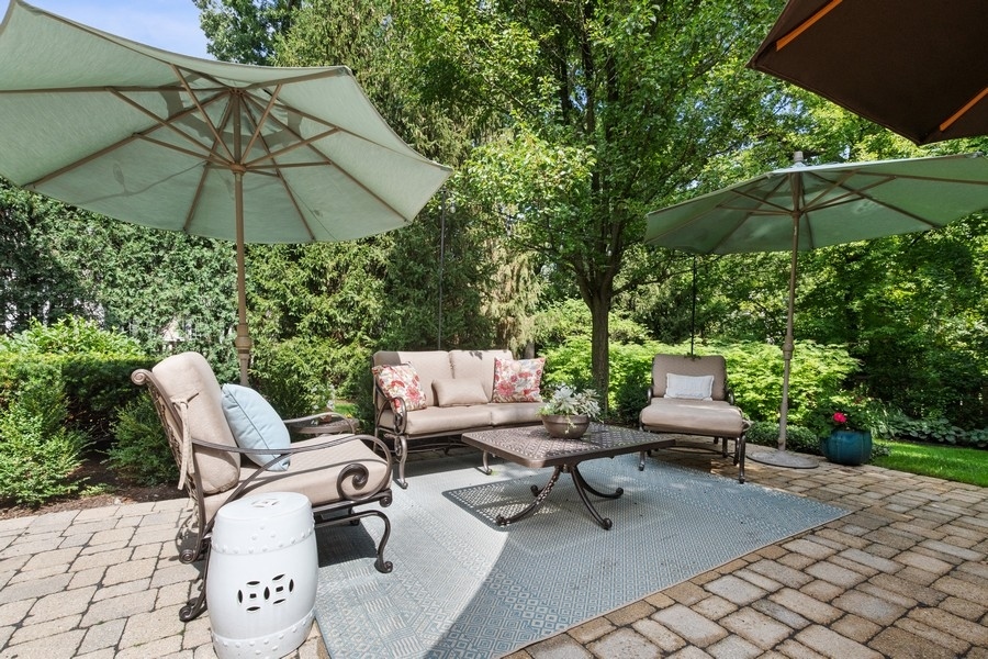 2239 Sheridan Road Highland Park, IL 60035 - Photo 46 of 46 a backyard of a house with table and chairs under an umbrella