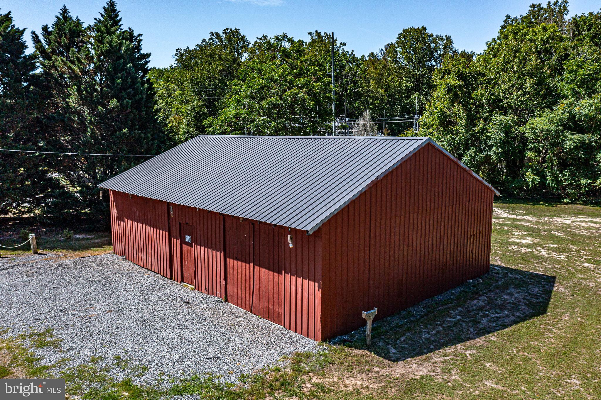 9832 River Road Lancaster, VA 22503 - Photo 47 of 68 Charming red barn amidst lush greenery.