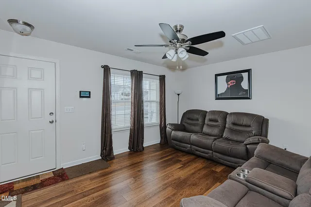 a living room with furniture and a ceiling fan
