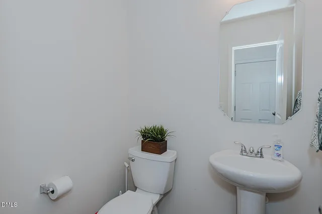 a bathroom with a sink toilet and a mirror
