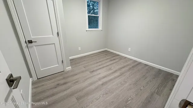 an empty room with wooden floor and white walls