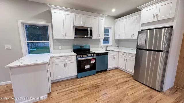a kitchen with a sink a microwave a refrigerator and cabinets