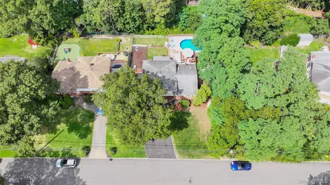 an aerial view of a house with a yard basket ball court and outdoor seating
