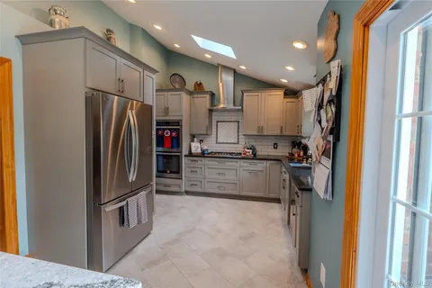 a kitchen with stainless steel appliances granite countertop a refrigerator and a sink