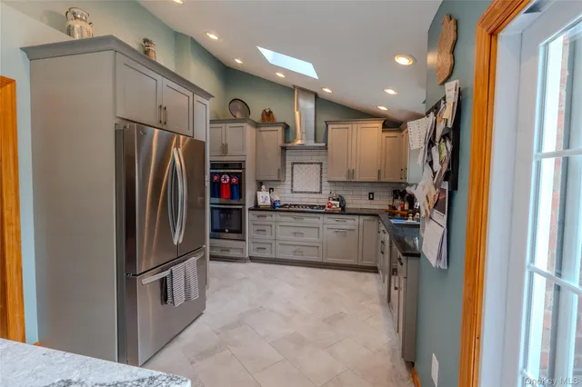 a kitchen with stainless steel appliances granite countertop a refrigerator and a sink
