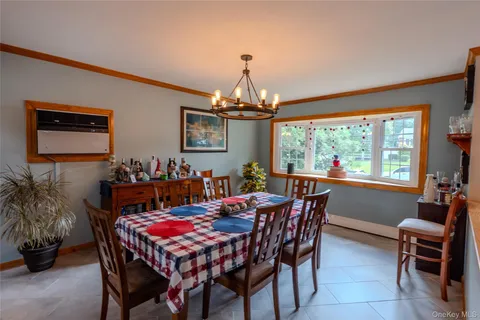 a dining room with furniture a chandelier and window