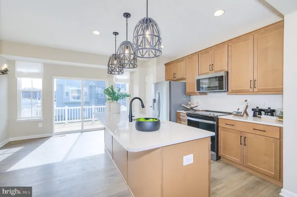 a large kitchen with stainless steel appliances kitchen island granite countertop a large kitchen island a stove a refrigerator and a view of living room