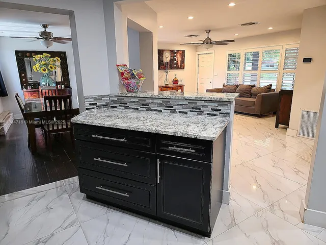 a kitchen with a stove a sink a dining table and chairs