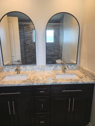a bathroom with double vanity sinks and a mirror