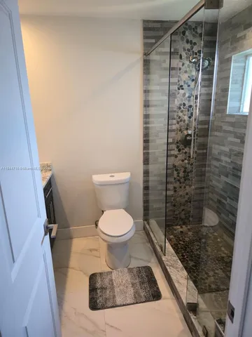 a bathroom with a toilet and a shower