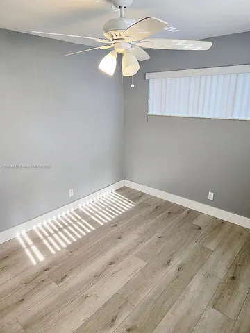 a view of wooden floor and chandelier fan in a room