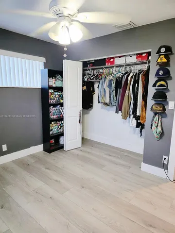 a view of walk in closet with clothes and shoes
