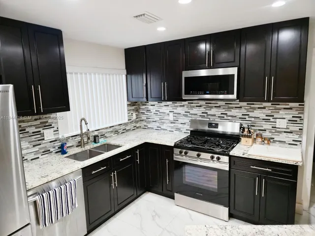 a kitchen with a sink stove and microwave