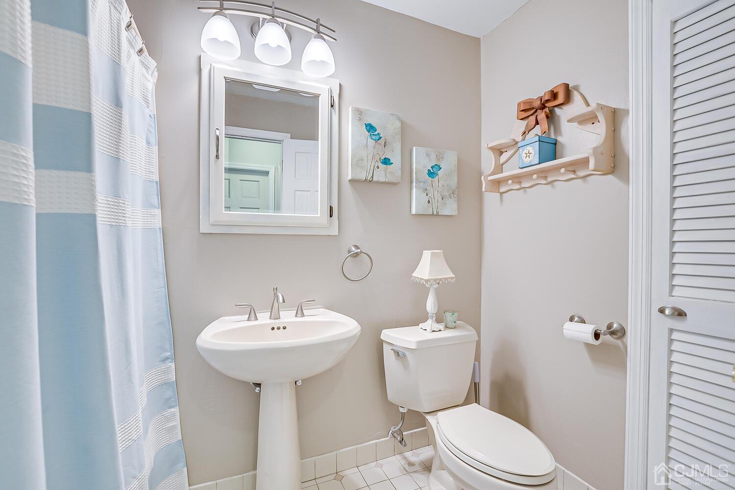 27 Homestead Road Edison, NJ 08820 - Photo 36 of 64 a bathroom with a toilet a sink and mirror