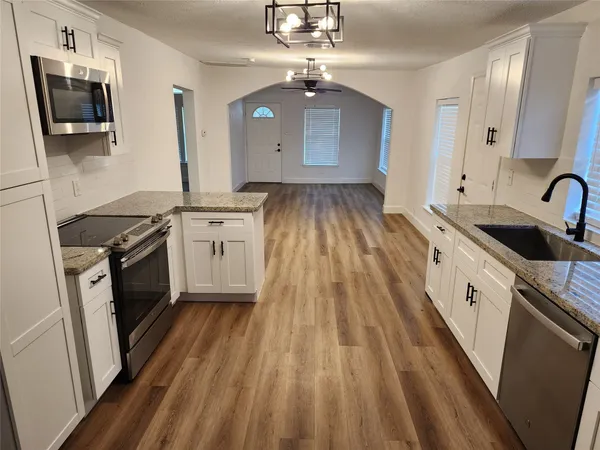a kitchen with a sink stove and cabinets