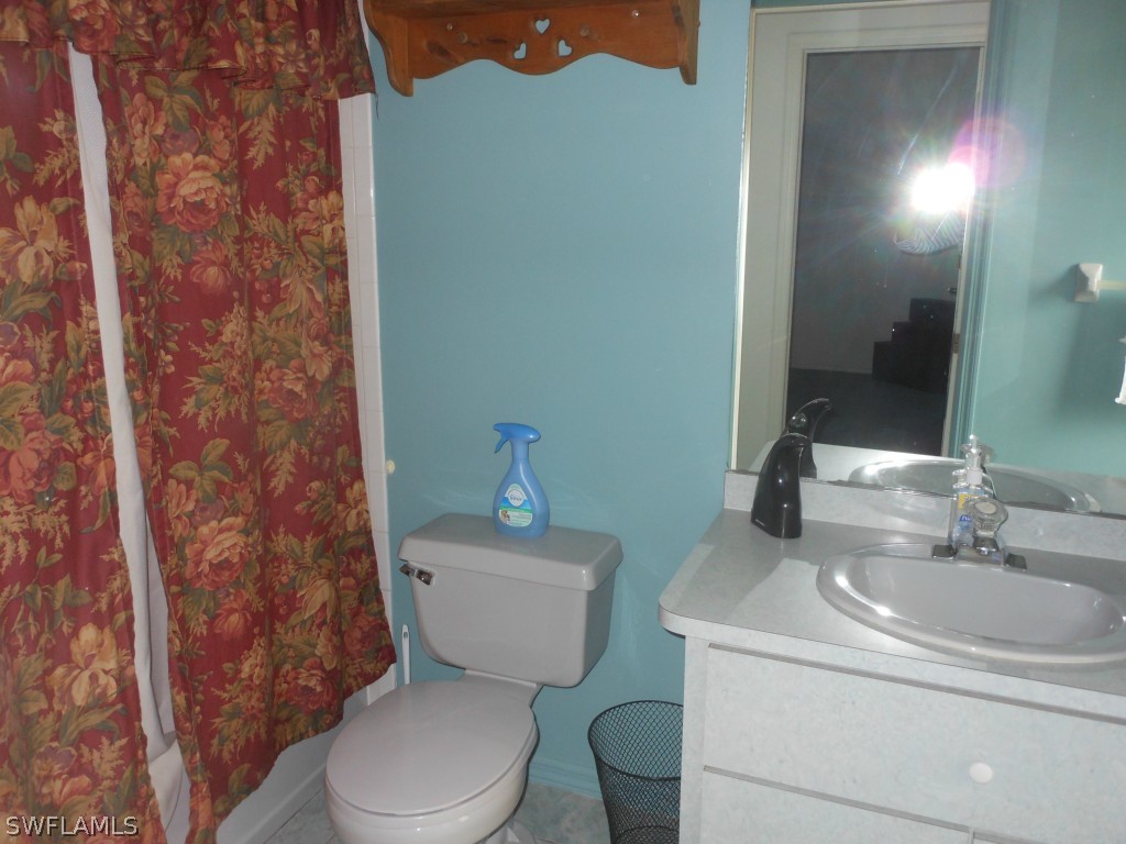17560 Homewood Road Fort Myers, FL 33967 - Photo 8 of 9 a bathroom with a toilet a sink and mirror