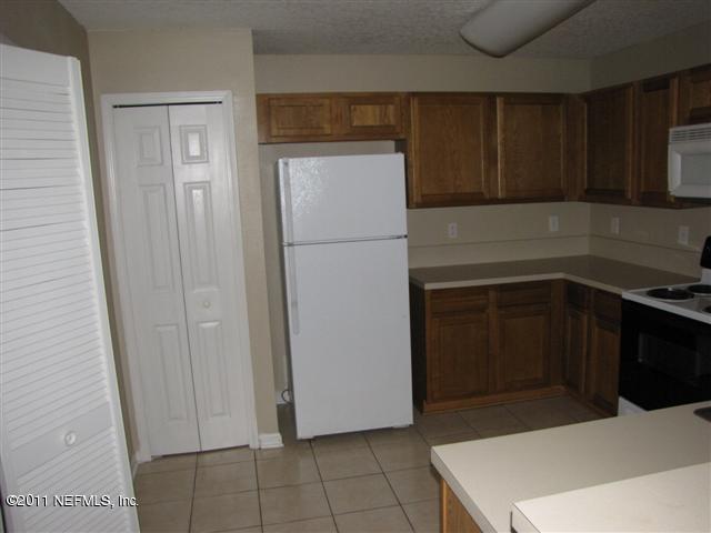 7920 Merrill Road, Unit 1816 Jacksonville, FL 32277 - Photo 4 of 10 a kitchen with a refrigerator and cabinets