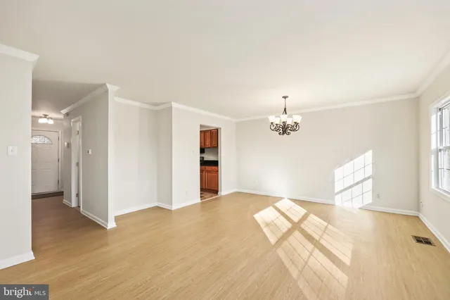 a view of empty room with wooden floor and window