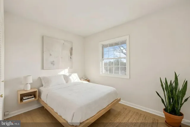 a bedroom with a bed and a potted plant