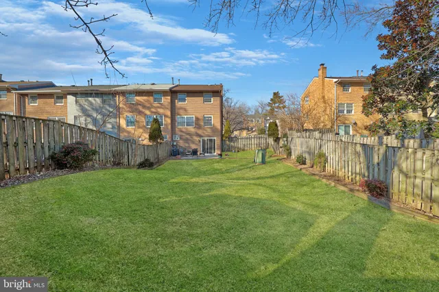 a view of a barn with a yard and large tree