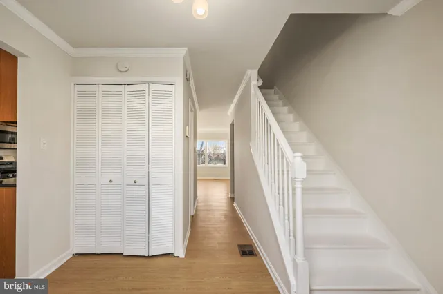 a view of a hallway with wooden floor and entryway
