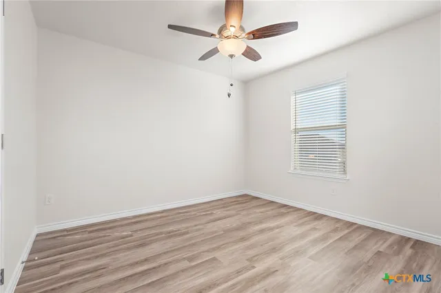 wooden floor in an empty room with a window