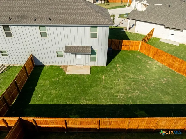 an aerial view of a house with wooden fence