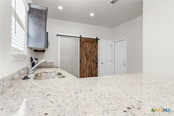 a view of a kitchen with a sink and cabinets