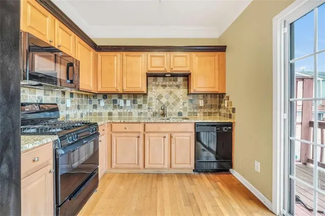 a kitchen with stainless steel appliances granite countertop a stove and white cabinets
