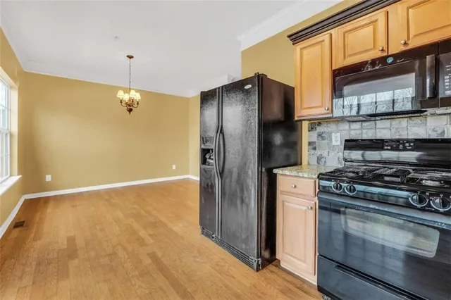 a kitchen with stainless steel appliances granite countertop a refrigerator and a stove top oven