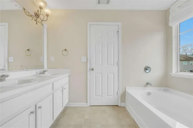 a bathroom with a tub sink and mirror