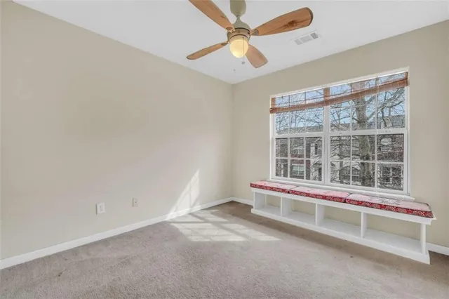 an empty room with a ceiling fan and window