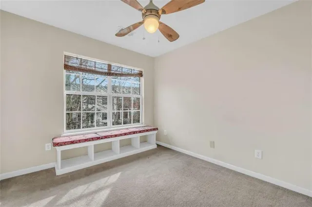 an empty room with a window and a ceiling fan