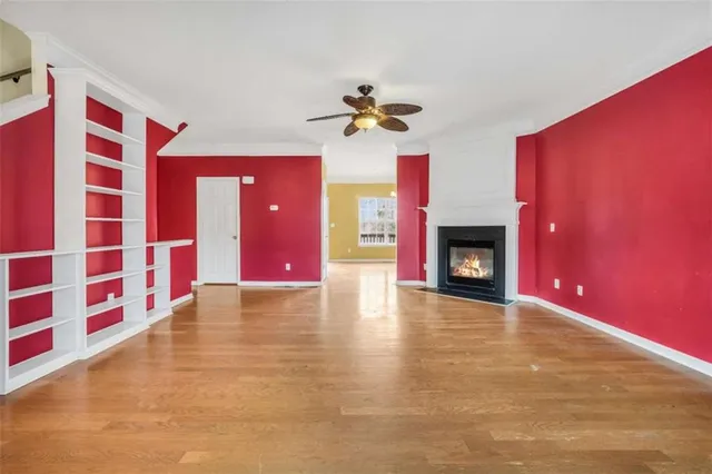 a view of an empty room with a fireplace and window