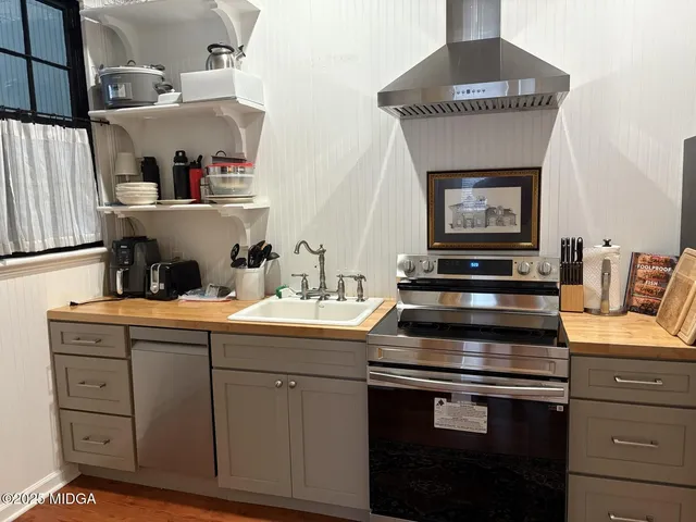 a kitchen with a stove and white cabinets