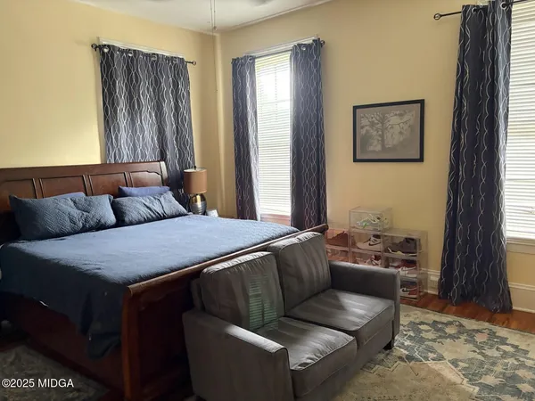 a bedroom with a bed couch and window